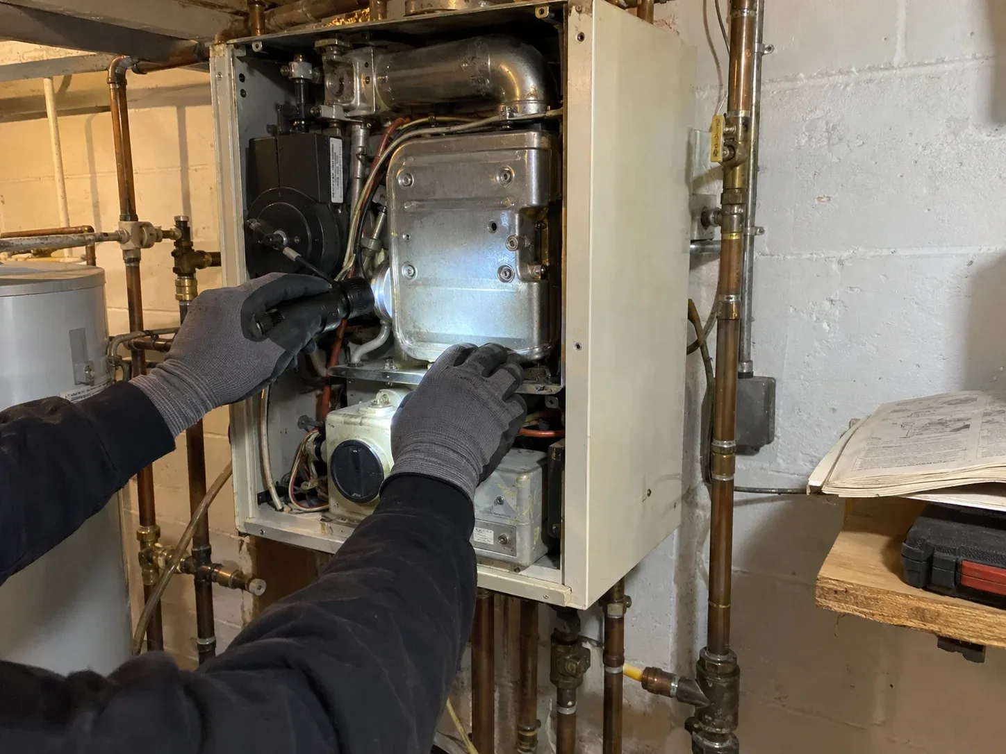 Older residential boiler being assessed for repair or replacement